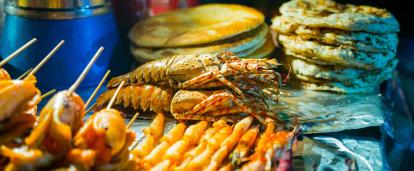 Travellers enjoy the variety of street food on sale during their Food Tour in Cambodia. Street food on sale at a local market in Cambodia.